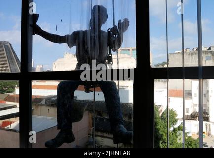 Abseilen Mann arbeiten an externen Fensterputzdienst und Gebäudereparatur. Arbeiter Abseilen Renovierung Gebäude. Zimmermann, Bauarbeiter Stockfoto