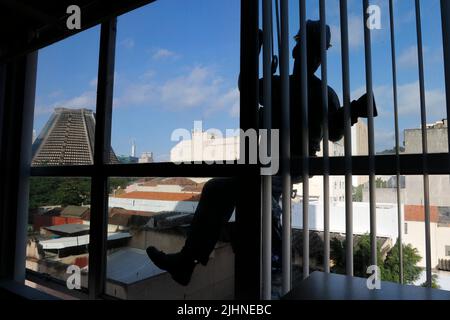 Abseilen Mann arbeiten an externen Fensterputzdienst und Gebäudereparatur. Arbeiter Abseilen Renovierung Gebäude. Zimmermann, Bauarbeiter Stockfoto