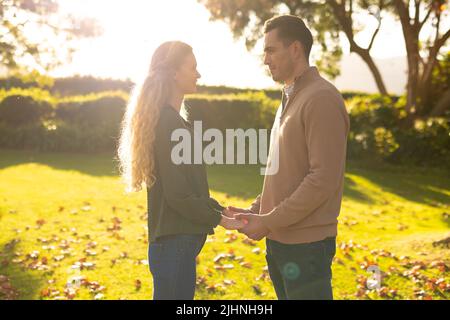 Bild eines glücklichen kaukasischen Paares, das die Hände im Garten hält Stockfoto