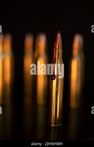 AR-15-Stil Gewehrpatrone und Blut (Fototafel). Stockfoto