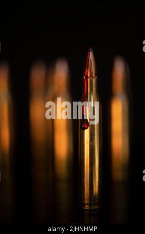 AR-15-Stil Gewehrpatrone und Blut (Fototafel). Stockfoto