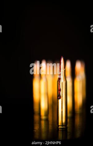 AR-15-Stil Gewehrpatrone und Blut (Fototafel). Stockfoto