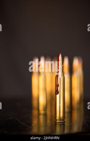 AR-15-Stil Gewehrpatrone und Blut (Fototafel). Stockfoto