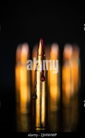 AR-15-Stil Gewehrpatrone und Blut (Fototafel). Stockfoto