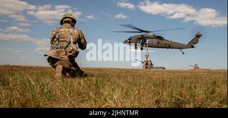 Soldaten, die Alpha Battery, 1. Bataillon, 320. Field Artillery Regiment „TOP GUNS“, 2. Brigade Combat Team „STRIKE“, 101. Airborne Division (Air Assault) zugewiesen wurden, führen Aufzugbohrer als Teil der Sling Load Operationen mit UH-60 Blackhawk Hubschrauber Piloten, die dem 3. Bataillon, 227. Aviation Regiment am 18. Juli 2022, In Mihail Kogalniceanu, Rumänien. 101. Einheiten werden die Mission des V-Korps unterstützen, um die Ostflanke der NATO zu stärken, und multinationale Übungen mit Partnern auf dem gesamten europäischen Kontinent durchführen, um unsere Verbündeten der Nationen zu beruhigen. (USA Foto der Armee von Staff Sgt. Malcolm Coh Stockfoto