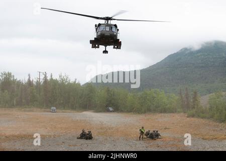 Eine Alaska Army National Guard UH-60L Black Hawk, die von einer Luftbesatzung betrieben wird, die dem Bataillon 1., 207. Aviation Truppenkommando, zugewiesen wurde, hebt ab, nachdem sie Spezialwaffen und Taktiken (SWAT)-Teamoffiziere der Polizeibehörde Anchorage auf der Joint Base Elmendorf-Richardson, Alaska, transportiert hat, 13. Juli 2022. Die umfangreichen und strengen Trainingsbereiche von JBER boten den SWAT-Teams der lokalen Strafverfolgungsbehörden einen idealen Rahmen, da sie ihre Fähigkeiten im ländlichen Betrieb, die Aufgabenplanung, die Aufklärung, die Sicherheitsverfahren für Hubschrauber, die Landnavigation, Teambewegung und Patrouille. (USA Luftwaffe Foto von Alejandro Peña) Stockfoto