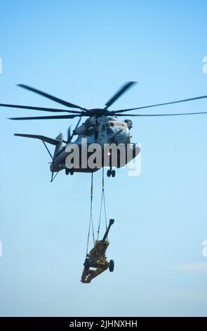 USMC CH-53E Super Hengst liefert eine Haubitze Stockfoto