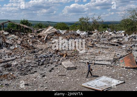 Slowjansk, Ukraine. 18.. Juli 2022. Ein Mann geht an den Ruinen zerstörter Wohnhäuser in Slowjansk vorbei. Slowjansk hatte 106.972 Einwohner (2021 Einwohner) und ist heute eine strategisch wichtige Stadt im Donezker Gebiet des Donbas, da die Stadt kontinuierlich von russischen Artillerien und Raketen bombardiert wurde, seit Kriegsbeginn haben bereits über 80 % der Zivilbevölkerung aus dem Krieg evakuiert. Kredit: SOPA Images Limited/Alamy Live Nachrichten Stockfoto