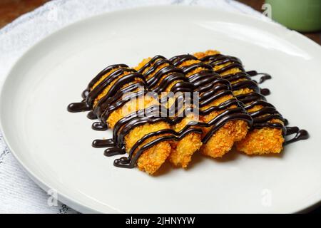 Gebratene Banane mit verschiedenen Belag, Chocochip, Matcha und Schokolade, Pisang Goreng Snack aus Indonesien Stockfoto