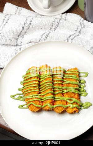 Gebratene Banane mit verschiedenen Belag, Chocochip, Matcha und Schokolade, Pisang Goreng Snack aus Indonesien Stockfoto