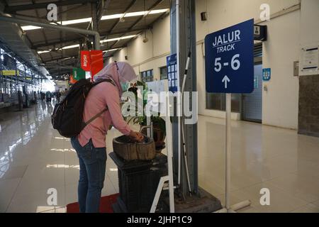 Solo, Indonesien. 16. Juli 2022. Eine muslimische Frau, die ihre Hand auf dem Bahnhof wascht. Es wird empfohlen, die Hände mit Seife zu waschen, um die Ausbreitung von Covid-19 zu reduzieren. Stockfoto