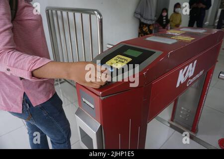 Solo, Indonesien - 16.. Juli 2022. Eine Frau strichen eine E-Money-Karte, um ein Ticket für die KRL-Pendlerlinie zu bezahlen, bevor sie den Bahnhof Solo Balapan betreten. Stockfoto