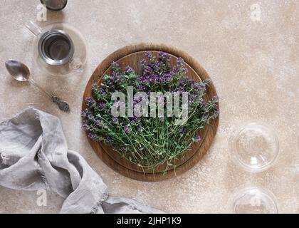 Thymus serpyllum, Thymian auf Holzschreibtisch mit leerer Teedose und Tassen, Draufsicht, Kopierraum Stockfoto