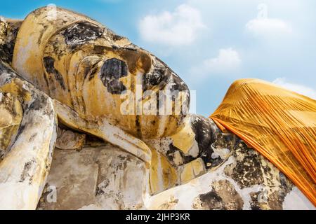 Liegende Buddha-Statue in festlicher safran-Kleidung aus nächster Nähe im Wat Lokaya Sutharam in Ayuttaya, Thailand. Liegende Buddha-Statue Stockfoto