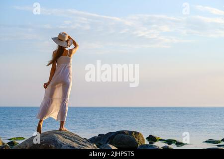 Nicht erkennbare weibliche Reisende bewundern Meer bei Sonnenuntergang Stockfoto
