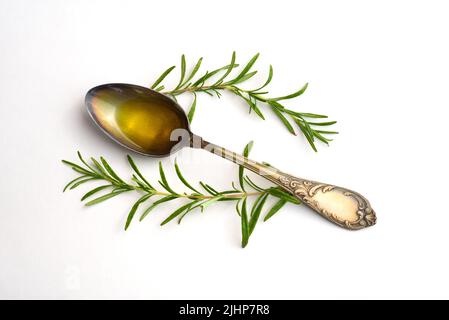 Olivenöl. Spanien Olivenöl in Löffel mit Rosmarin auf weißem Hintergrund. Stockfoto