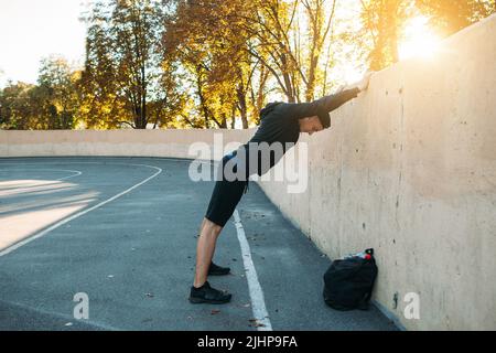 Sportler macht Aufwärmübungen Stockfoto