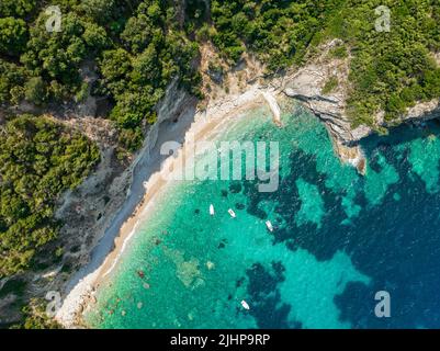 Luftaufnahme des Kolias Strandes auf der Insel Korfu. Griechenland. Klippen mit Blick auf den Strand und ein unberührtes grünes und blaues Meer. Festfahrte Boote Stockfoto