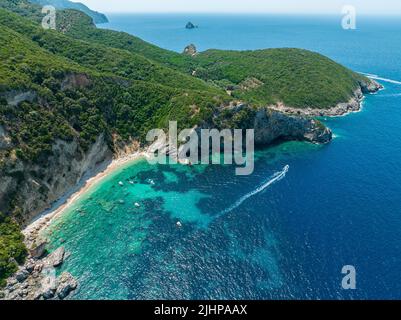 Luftaufnahme des Kolias Strandes auf der Insel Korfu. Griechenland. Klippen mit Blick auf den Strand und ein unberührtes grünes und blaues Meer. Festfahrte Boote Stockfoto