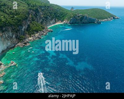 Luftaufnahme des Kolias Strandes auf der Insel Korfu. Griechenland. Klippen mit Blick auf den Strand und ein unberührtes grünes und blaues Meer. Festfahrte Boote Stockfoto