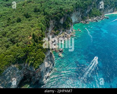 Luftaufnahme des Kolias Strandes auf der Insel Korfu. Griechenland. Klippen mit Blick auf den Strand und ein unberührtes grünes und blaues Meer. Festfahrte Boote Stockfoto