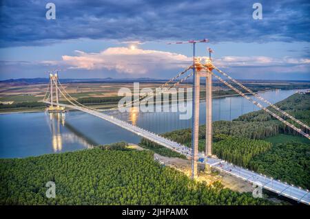 Panorama-Drohnenaufnahme von oben auf der schwebenden Brücke über die donau, die im Bau ist, zwischen Braila und Tulcea Städten in Rumänien Stockfoto