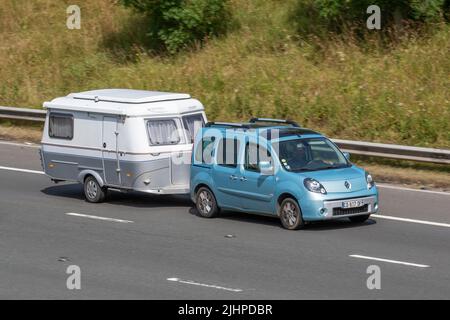 Renault Kangoo, französische Touristen, die einen ERIBA-GT-Wohnwagen schleppen; unterwegs auf der Autobahn M6, Manchester, Großbritannien Stockfoto