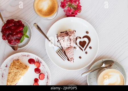 Auswahl an natürlichen veganen, geschichteten Desserts, Stück Kuchen mit frischen Früchten und Beeren. Feier, Süßigkeitenauswahl auf der Terrasse. Stockfoto