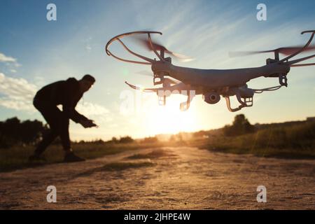 Pilot läuft Drohne bei Sonnenuntergang Licht, freien Raum Stockfoto