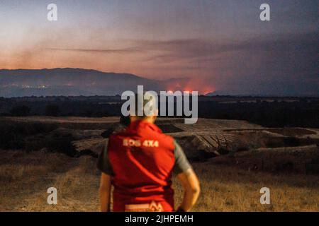 Madrid, Spanien. 19.. Juli 2022. Eine Person beobachtet den Rauch und das Feuer von Valdepeñas de la Sierra. Das Feuer der Valdepeñas de la Sierra in Guadalajara, Spanien, zerstört 2.300 Hektar und hinterlässt Dutzende von Familien obdachlos. Die Brände ereigneten sich im Zusammenhang mit der Sommersaison und den hohen Lufttemperaturen und starken Winden, doch die Behörden schließen nicht aus, dass das Feuer hätte provoziert werden können. Kredit: SOPA Images Limited/Alamy Live Nachrichten Stockfoto