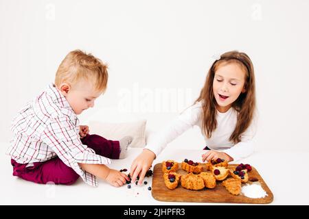 Mädchen Konditorin schreit Bruder verstörend an Stockfoto