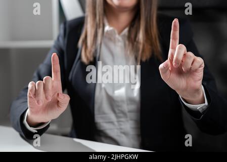 Geschäftsfrau Zeigt Mit Zwei Fingern Auf Wichtige Botschaften. Executive In Suit Präsentiert Verschiedene Informationen Über Die Krutialebene. Frau Zeigt Kritisch Stockfoto