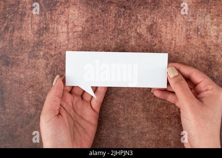 Hände Der Frau Halten Rede Blase Von Leerem Papier Über Holzhintergrund. Geschäftsfrau Mit Leerem Blatt Und Darstellung Von Gedanken Und Geschäft Stockfoto