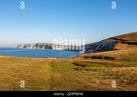 Blick entlang eines Küstenweges auf der Isle of Wight mit Blick auf die Kreidefelsen der Freshwater Bay über dem Meer Stockfoto