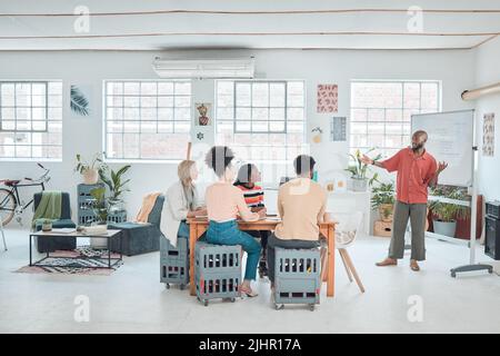 Eine Gruppe von verschiedenen Geschäftsleuten, die sich in einem modernen Büro auf der Arbeit treffen. Junger glücklicher afroamerikanischer Geschäftsmann, der eine Idee vorführt Stockfoto