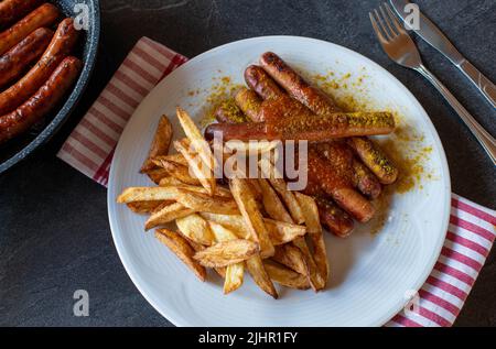 Wiener Würstchen mit hausgemachten pommes frites und einer Sauce aus dem Hause Stockfoto