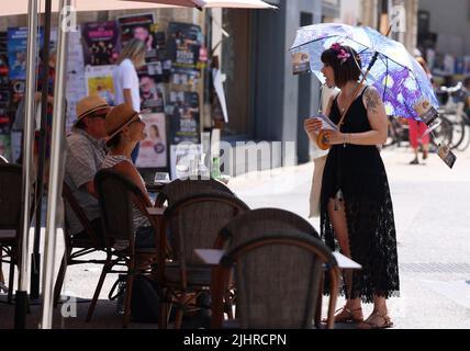 Avignon, Frankreich. 19.. Juli 2022. Eine Künstlerin promotet ihr Drama auf der Straße während des Festival d'Avignon 76. in Avignon, Frankreich, am 19. Juli 2022. Das Festival, das 1947 vom französischen Dramaturgen Jean Vilar ins Leben gerufen wurde, ist eines der bedeutendsten zeitgenössischen Veranstaltungen der darstellenden Kunst der Welt. Kredit: Gao Jing/Xinhua/Alamy Live Nachrichten Stockfoto