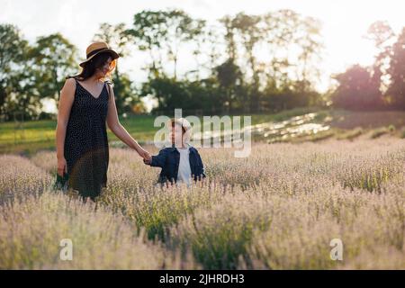 Glückliche Mutter und kleiner Sohn verbringen Zeit zusammen im Lavendelfeld Stockfoto