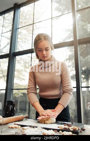 Junge Frau kneten Teig in der Küche, Bäckerei machen Stockfoto