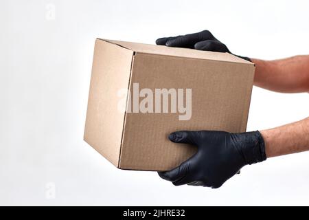 Lieferung Mann Hand in Handschuhen mit Verpackung Box Stockfoto