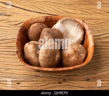 Shitake Pilze in einer Schüssel über Holztisch. Stockfoto