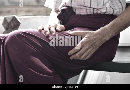 Oberschenkelschmerzen bei einem älteren männlichen Patienten in Asien. Konzept der Ischias oder Ischiasnerv Schmerzen. Stockfoto