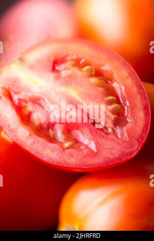Tomatenscheibe, Nahaufnahme von frisch geernteten roten Beeren, aufgenommen in geringer Schärfentiefe, Makro Stockfoto