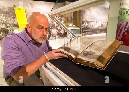 Birmingham, Großbritannien. 20.. Juli 2022. Tom Epps, Cultural Partnership Manager der Library of Birmingham, nimmt eine abschließende Anpassung an das seltene Shakespeare First Folio aus dem Jahr 1623 vor, bevor es zusammen mit vielen anderen bisher unsichtbaren Shakespeare-Artikeln und Büchern in der Library of Birmingham gezeigt wird. Die Ausstellung „alles für alle: Euer Shakespeare, eure Kultur“ läuft vom 22.. Juli bis zum 2022. November. Kredit: Peter Lopeman/Alamy Live Nachrichten Stockfoto