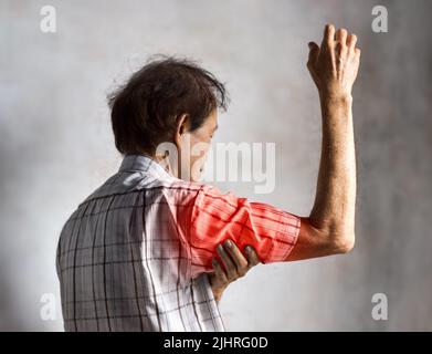 Schmerzen im Oberarm des älteren Mannes aus Südostasien. Konzept der gefrorenen Schulter. Stockfoto