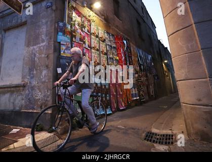 Avignon, Frankreich. 19.. Juli 2022. Ein Radfahrer passiert auf der Straße während des Festival d'Avignon 76. in Avignon, Frankreich, 19. Juli 2022, Dramaplakate. Das Festival, das 1947 vom französischen Dramaturgen Jean Vilar ins Leben gerufen wurde, ist eines der bedeutendsten zeitgenössischen Veranstaltungen der darstellenden Kunst der Welt. Kredit: Gao Jing/Xinhua/Alamy Live Nachrichten Stockfoto