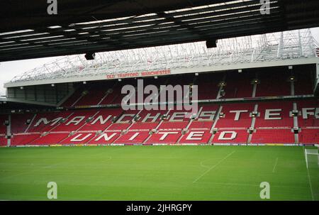 1990s, Blick auf das Old Trafford Stadium, Heimstadion des Manchester United Football Club, Manchester, England, Großbritannien. Der Name des berühmten Clubs in Nordengland, der in Weiß auf den Sitzplätzen steht und rot ist, ist die Farbe des Clubs. Stockfoto