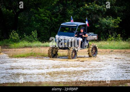 Ein ATV mit Leuten, die beim Rock Fest 2020 auf einem schmutzigen Schlammfeld herumfahren und Rennen Stockfoto