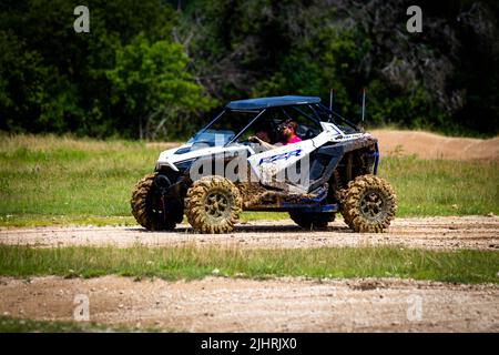 Ein ATV mit Leuten, die beim Rock Fest 2020 auf einem schmutzigen Schlammfeld herumfahren und Rennen Stockfoto