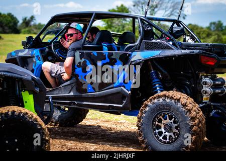 Ein ATV mit Leuten, die beim Rock Fest 2020 auf einem schmutzigen Schlammfeld herumfahren und Rennen Stockfoto